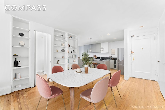 dining room featuring light hardwood / wood-style floors and built in shelves