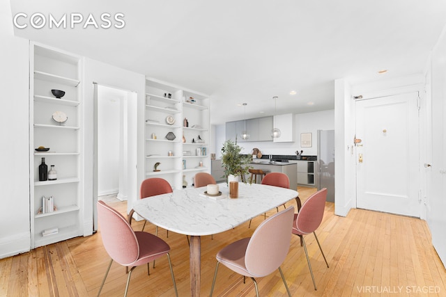 dining area featuring recessed lighting, built in shelves, and light wood finished floors