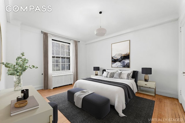 bedroom featuring radiator and light wood-type flooring