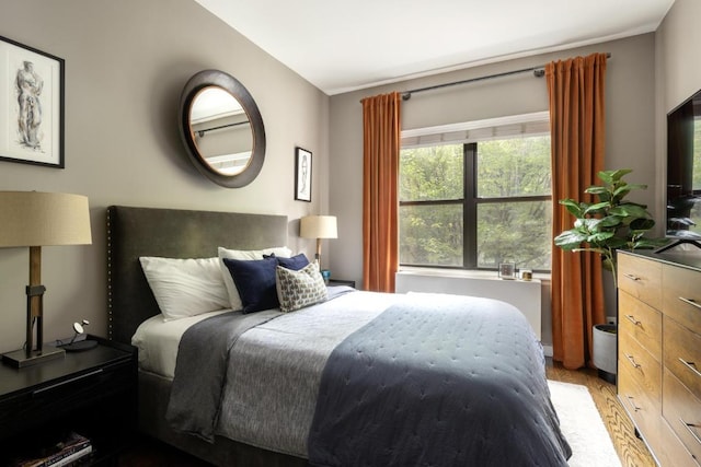 bedroom featuring radiator and light hardwood / wood-style floors