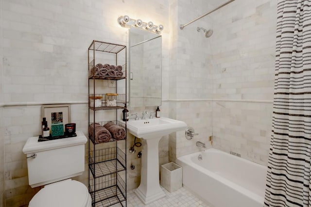 bathroom featuring shower / bath combination with curtain, toilet, tile patterned flooring, and tile walls