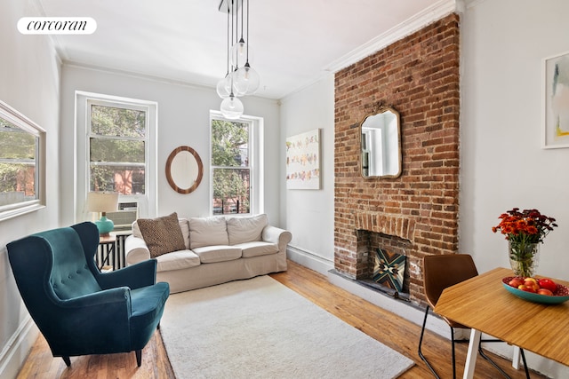 living room with ornamental molding, a fireplace, and wood-type flooring