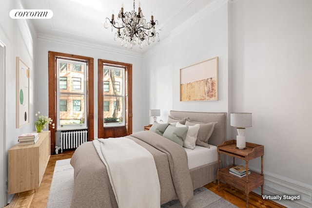 bedroom featuring radiator, a chandelier, ornamental molding, and light hardwood / wood-style flooring