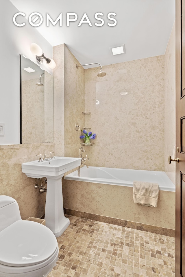 full bathroom with toilet, tile walls, and bathing tub / shower combination