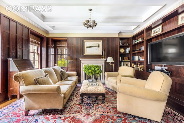 sitting room featuring built in features, wood finished floors, crown molding, a chandelier, and beam ceiling