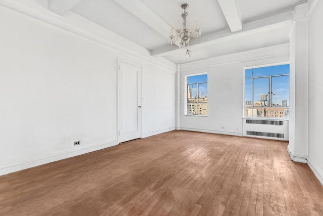 spare room featuring radiator heating unit, a notable chandelier, hardwood / wood-style flooring, and beamed ceiling