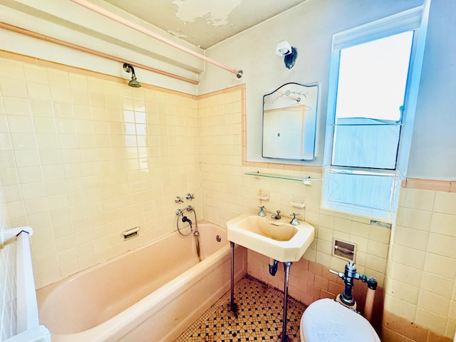 bathroom with tile walls, toilet, and bathing tub / shower combination