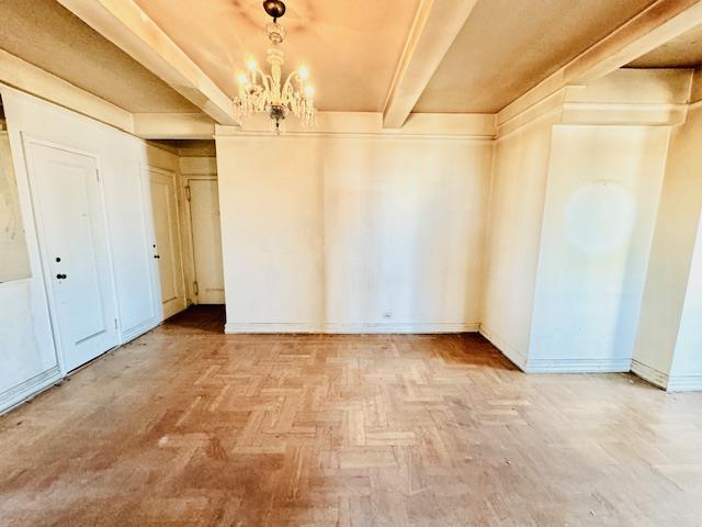 565 W End Ave Unit 19-C, New York City, NY 10024 - unfurnished room with a chandelier and beam ceiling