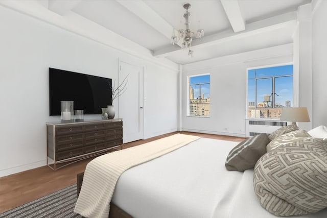 565 W End Ave Unit 19-C, New York City, NY 10024 - bedroom featuring radiator, wood finished floors, beamed ceiling, and a chandelier
