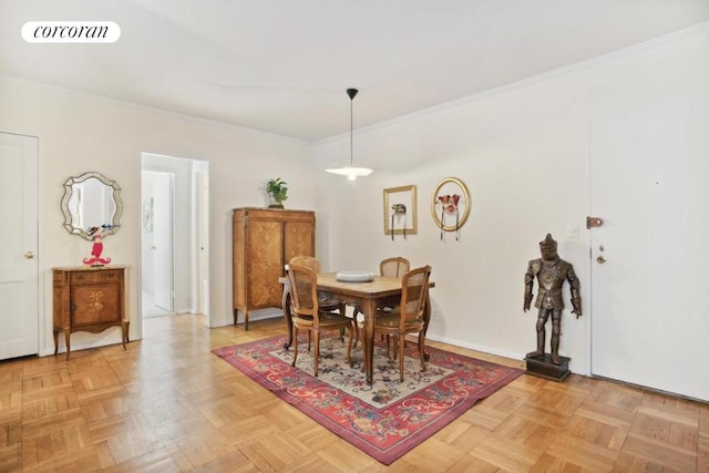 dining space with ornamental molding and light parquet flooring