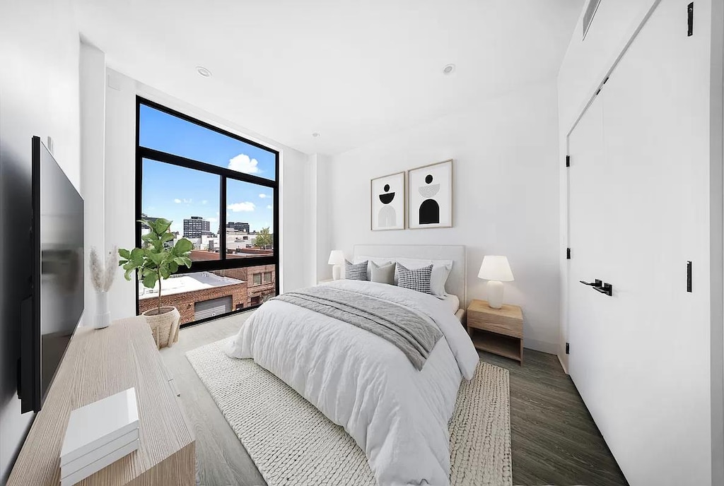 bedroom with wood finished floors and floor to ceiling windows