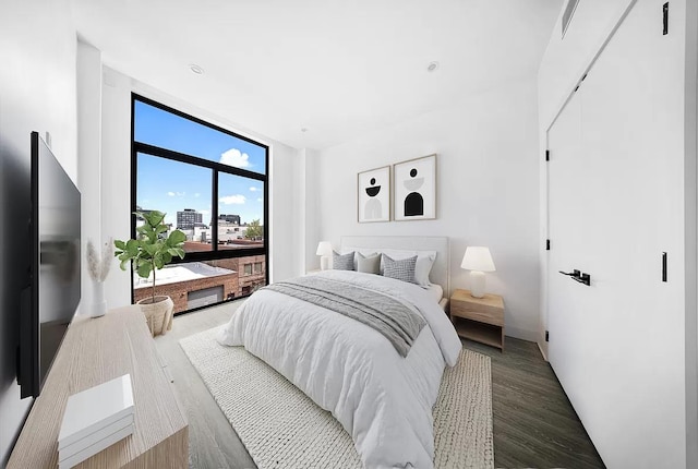 bedroom with wood finished floors and floor to ceiling windows