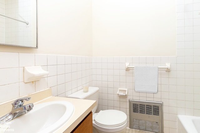 bathroom with toilet, a bath, radiator heating unit, vanity, and tile walls