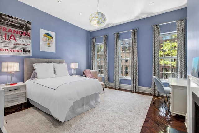 bedroom with a notable chandelier and dark hardwood / wood-style flooring