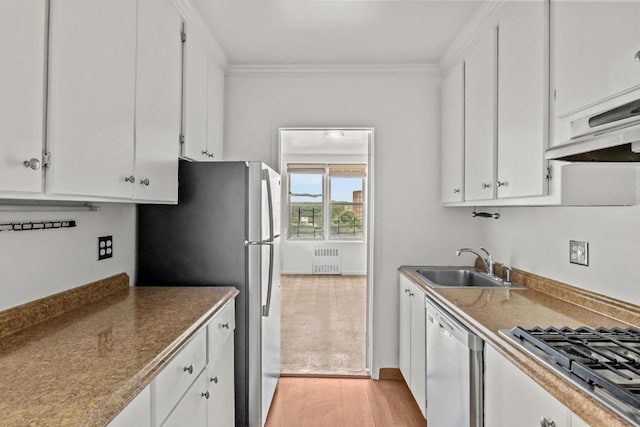 kitchen with sink, white cabinets, radiator, and stainless steel appliances