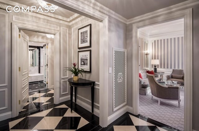 hall with baseboards, a decorative wall, and crown molding