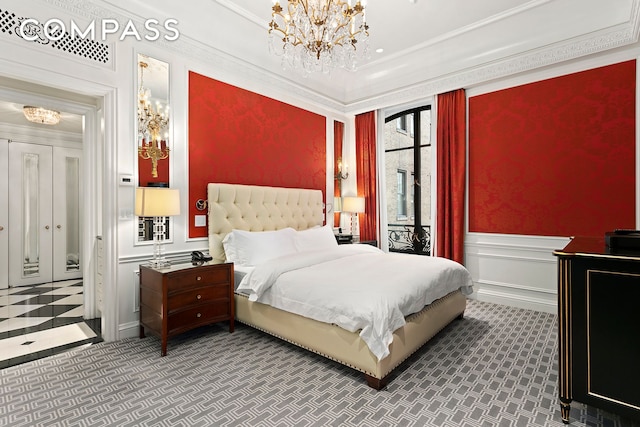 carpeted bedroom with a decorative wall, a wainscoted wall, a chandelier, and ornamental molding