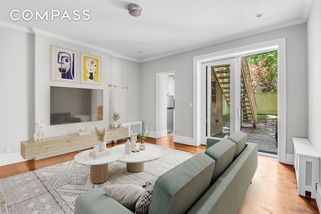 living room with crown molding and light hardwood / wood-style floors