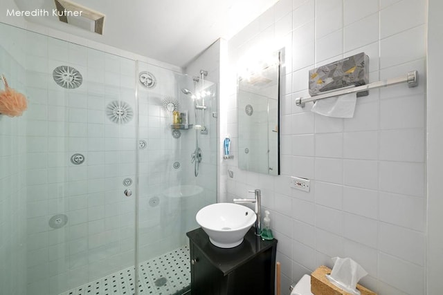 bathroom with vanity, tile walls, and a tile shower