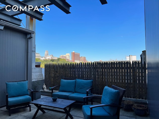 view of patio / terrace with fence, an outdoor living space, and a view of city