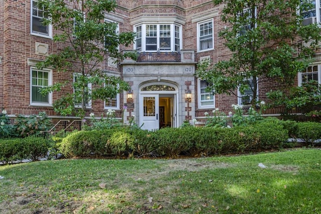 property entrance featuring brick siding and a yard