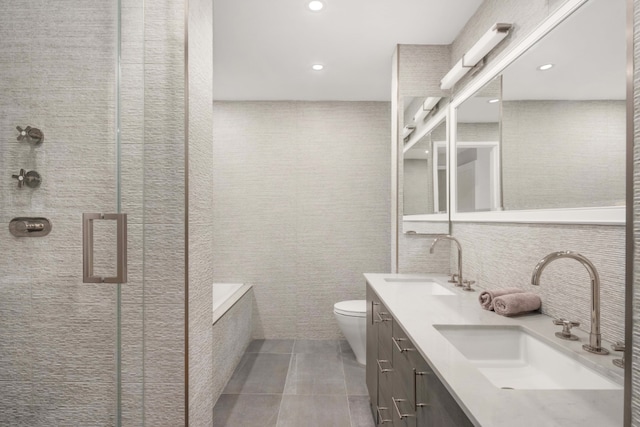 full bathroom with tile walls, separate shower and tub, vanity, tile patterned floors, and toilet