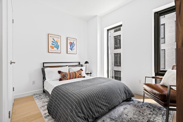 bedroom featuring light wood-type flooring and baseboards