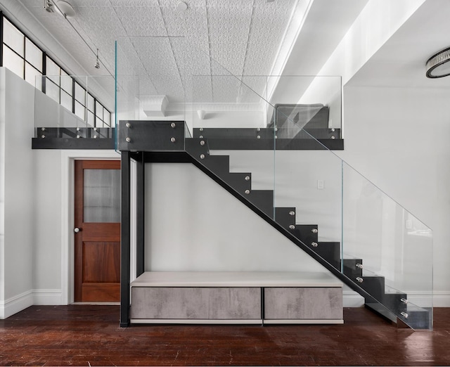 staircase featuring wood finished floors and baseboards