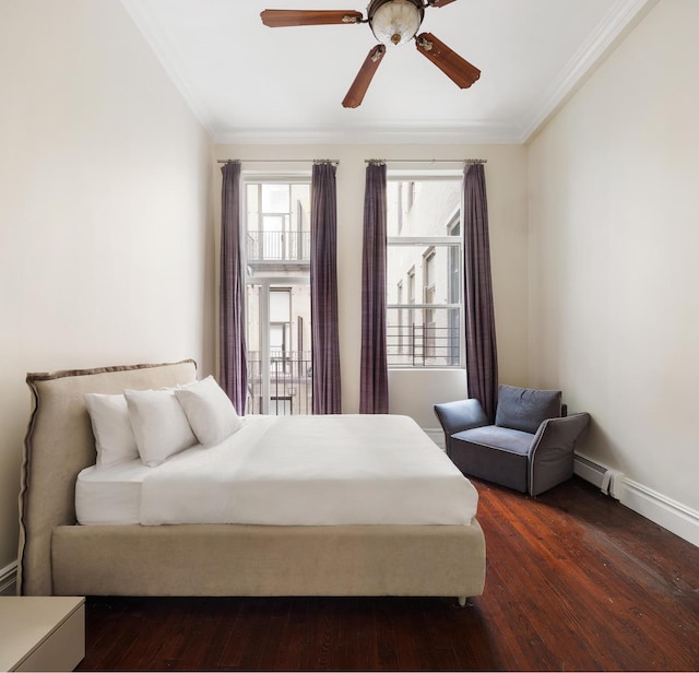 bedroom featuring dark wood-type flooring, a baseboard heating unit, and crown molding