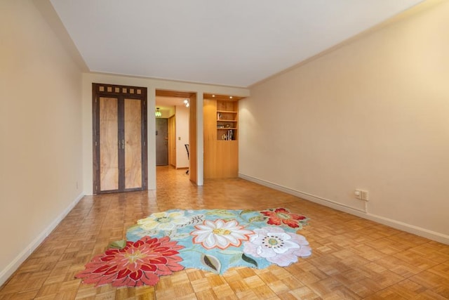 empty room featuring built in shelves and light parquet flooring