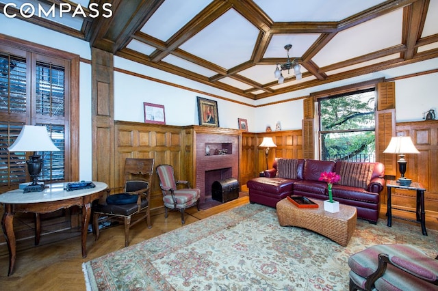 living room featuring a fireplace, coffered ceiling, parquet floors, and ornamental molding