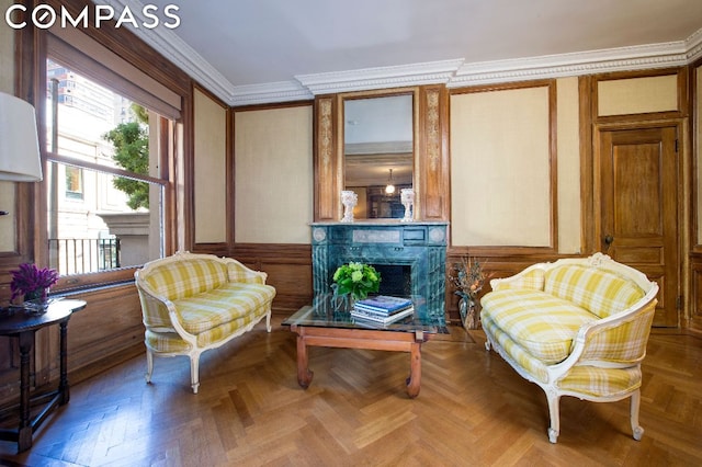 living area with a high end fireplace, ornamental molding, and parquet floors