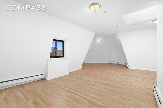 336 Convent Avenue Mltfmly, New York City, NY 10031 - spare room with a baseboard heating unit, a baseboard radiator, a skylight, light wood-style flooring, and a pendent fire sprinkler