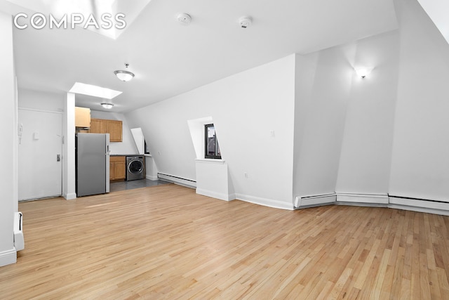 336 Convent Avenue Mltfmly, New York City, NY 10031 - unfurnished living room featuring washer / clothes dryer, baseboard heating, and light wood-style floors
