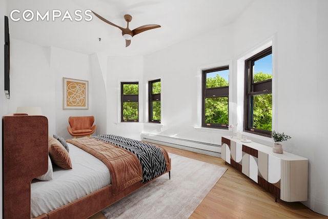 336 Convent Avenue Mltfmly, New York City, NY 10031 - bedroom with baseboard heating, light wood-style flooring, and a ceiling fan