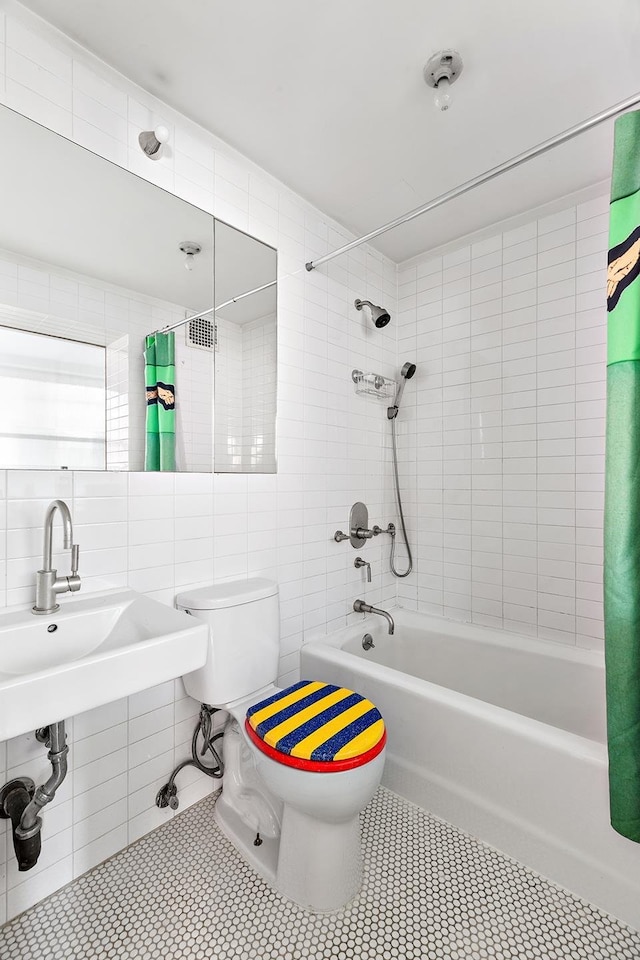 bathroom with tile walls, shower / bath combination with curtain, backsplash, toilet, and tile patterned flooring