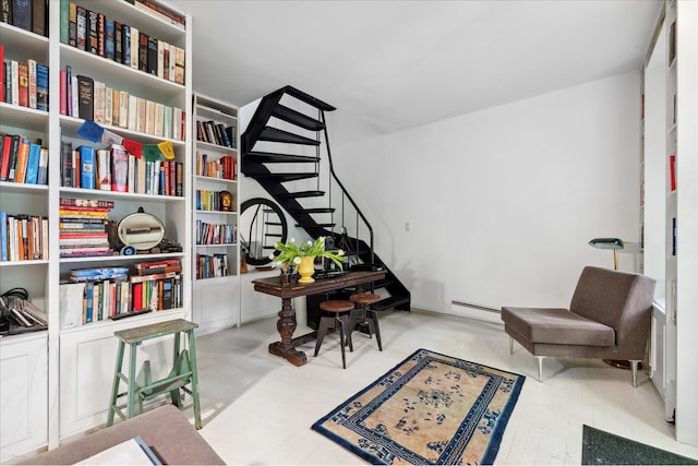 sitting room with a baseboard radiator and stairway