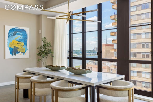 unfurnished dining area with baseboards, floor to ceiling windows, a view of city, breakfast area, and dark wood finished floors