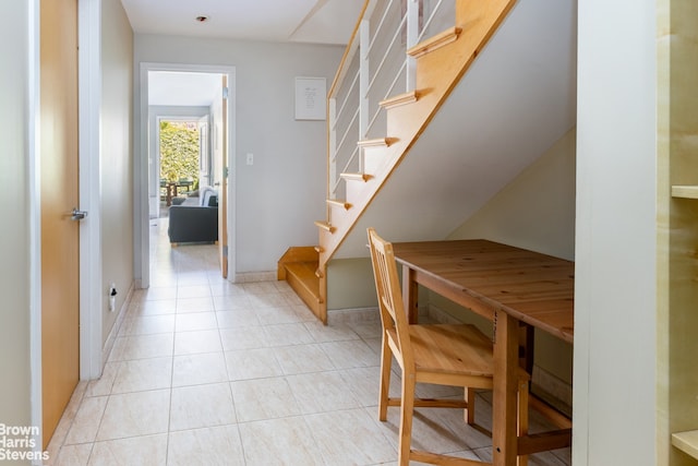 interior space featuring stairs, baseboards, and light tile patterned floors