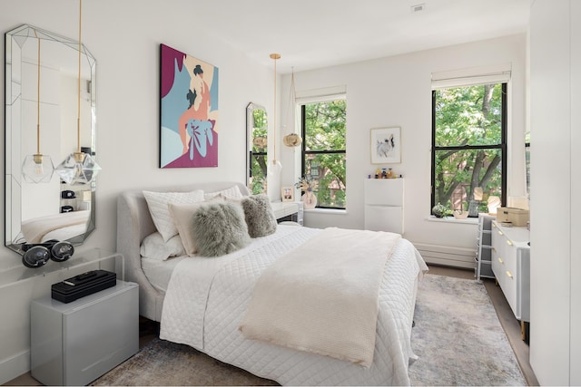 bedroom featuring wood finished floors and freestanding refrigerator