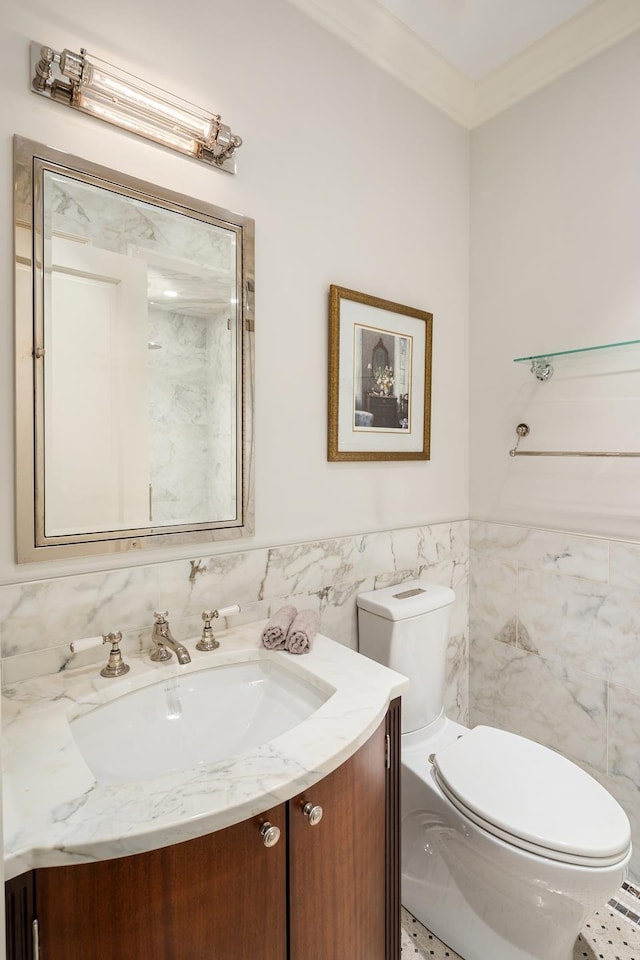 half bath featuring toilet, tile walls, ornamental molding, and vanity