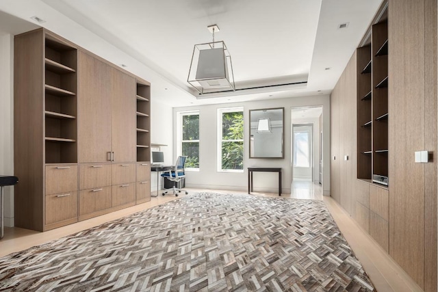 living area featuring built in features, a tray ceiling, and built in desk