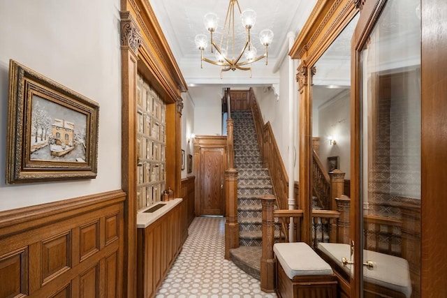 corridor featuring stairs, wainscoting, and crown molding