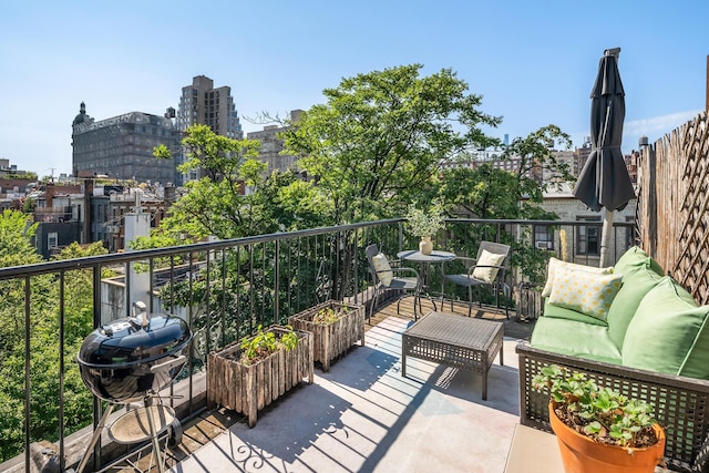 balcony with an outdoor hangout area, area for grilling, and a view of city