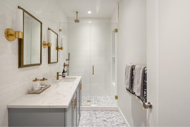 bathroom featuring a shower stall, tile walls, and vanity