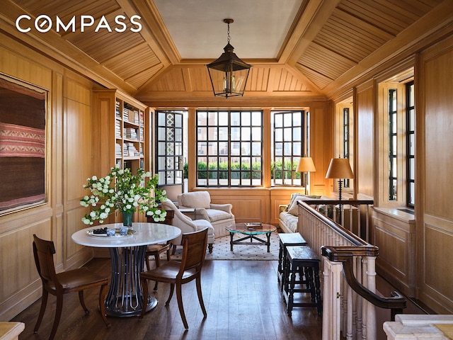 living area with wooden ceiling, wooden walls, dark wood-style floors, and vaulted ceiling with beams