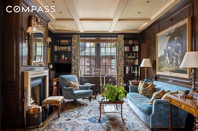 living area featuring crown molding, built in features, a fireplace, coffered ceiling, and beam ceiling