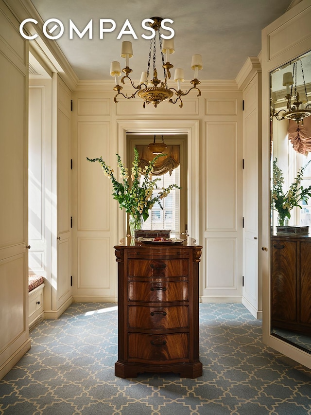 foyer entrance with a chandelier, a decorative wall, and carpet floors
