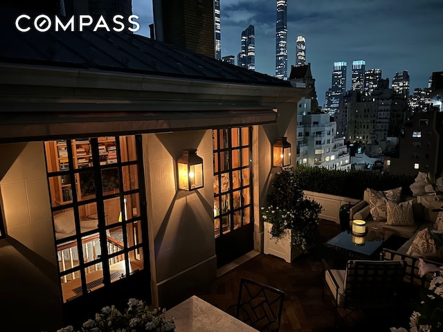 patio at twilight featuring a view of city lights