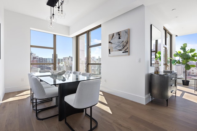 dining space with a view of city, dark wood finished floors, and baseboards